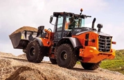 New Loader lifting dirt in field,New Hitachi Loader on construction site,Hitachi Loader moving dirt,Hitachi loader scoping up dirt,Hitachi loader scoping up dirt